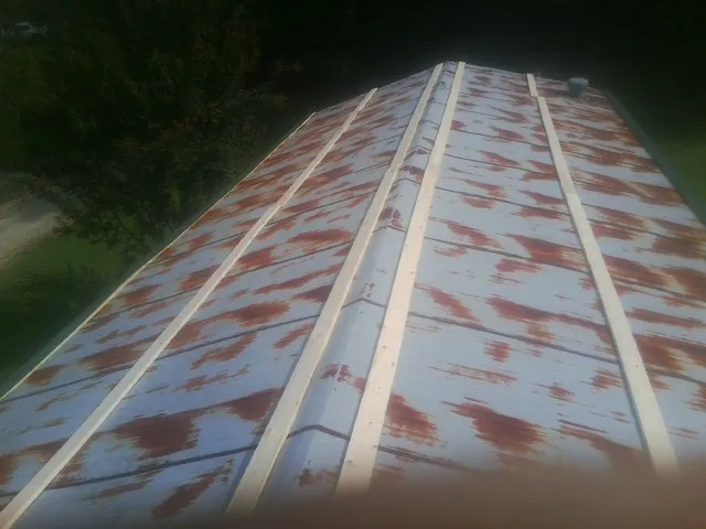 Rusted metal roof panels with new wood purlins before replacement — Storm Damage Roof Repair in Slovan by Roofing Brothers