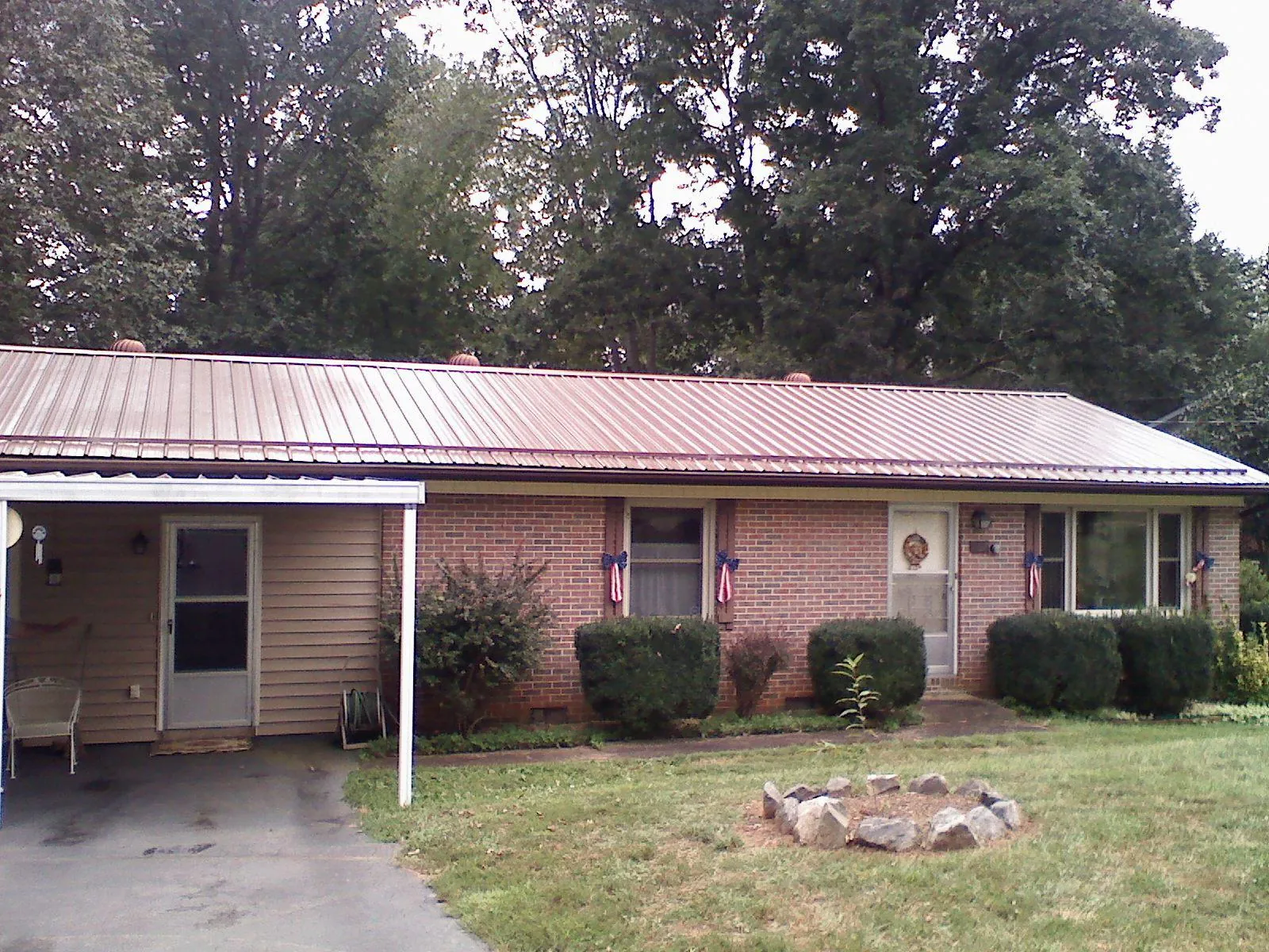 Bronze metal roof and carport on a brick ranch home — Roof Repair work by our crew in Slovan